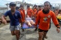 Rescue workers carry a woman about to give birth - Tacloban Airport